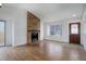 Cozy living room showcasing a brick fireplace, large window, and an abundance of natural light at 4542 S Quintero St, Aurora, CO 80015