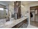 Elegant bathroom with granite countertops, dual sinks, decorative vases, and a separate walk-in closet at 1158 Sugarloaf Ln, Erie, CO 80516