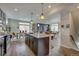 Open-concept kitchen with a large granite island, pendant lighting, and views into the dining and living areas at 1158 Sugarloaf Ln, Erie, CO 80516