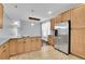 Bright kitchen featuring stainless steel refrigerator, eat in island, stylish light fixtures and tile flooring at 3612 Hudson St, Denver, CO 80207