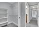 Bright walk-in closet with custom shelving and ample storage space, leading to well-lit hallway at 3612 Hudson St, Denver, CO 80207