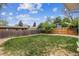 Large, green backyard with a wooden fence, providing privacy and space for outdoor activities at 7192 W 67Th Pl, Arvada, CO 80003