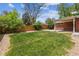 Spacious backyard featuring lush green lawn, patio, and privacy fence, perfect for outdoor activities at 7192 W 67Th Pl, Arvada, CO 80003