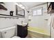 Bathroom with subway tile, yellow bathtub, dark vanity, and decorative mirror at 7192 W 67Th Pl, Arvada, CO 80003