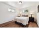 Bedroom with hardwood floors, view of yard through windows, and bedside tables at 7192 W 67Th Pl, Arvada, CO 80003
