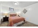Comfortable bedroom featuring a patterned comforter, two lamps, and neutral carpet at 7192 W 67Th Pl, Arvada, CO 80003