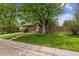 Well-maintained front yard with a classic brick home and mature trees in a quiet neighborhood at 7192 W 67Th Pl, Arvada, CO 80003