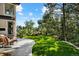 Grassy backyard with lush trees and patio seating with lovely hillside views at 918 Dakota Dr, Castle Rock, CO 80108