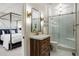 Well-lit bathroom features wood vanity, shower with glass door, and adjacent bedroom area at 918 Dakota Dr, Castle Rock, CO 80108