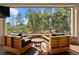 Cozy outdoor seating area with a stone fireplace and views of the surrounding nature at 918 Dakota Dr, Castle Rock, CO 80108