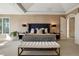 Elegant primary bedroom with a upholstered headboard, bench seating, and an arched doorway at 918 Dakota Dr, Castle Rock, CO 80108