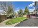 Backyard with a wooden fence, featuring a deck and a well maintained lawn at 3680 S Gibralter Cir, Aurora, CO 80013