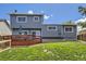 View of a 2-story home's backyard featuring a wooden deck and well-maintained yard at 3680 S Gibralter Cir, Aurora, CO 80013