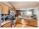 Modern kitchen with stainless steel appliances, wood cabinets, and granite countertops at 3680 S Gibralter Cir, Aurora, CO 80013