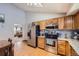 Spacious kitchen featuring wood cabinets, stainless steel appliances, and a view into the living area at 3680 S Gibralter Cir, Aurora, CO 80013