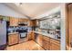 Cozy kitchen features wood cabinets, stainless steel appliances, and a large window for natural light at 3680 S Gibralter Cir, Aurora, CO 80013