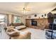 Inviting living room with brick fireplace, ceiling fan, and large window with natural light at 3680 S Gibralter Cir, Aurora, CO 80013