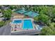 Aerial view of community pool and tennis courts with lush landscaping and a playground at 10289 E Berry Dr, Greenwood Village, CO 80111