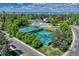 Aerial view of tennis courts, swimming pool, and clubhouse surrounded by lush trees at 10289 E Berry Dr, Greenwood Village, CO 80111