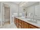 Bright bathroom featuring double sinks, wood cabinets, and a shower and tub combo at 10289 E Berry Dr, Greenwood Village, CO 80111