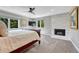 Serene bedroom with marble fireplace, plush carpet, and ample natural light from multiple windows at 10289 E Berry Dr, Greenwood Village, CO 80111