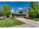 Charming two-story home with brick accents, manicured lawn, mature trees, and an attached two-car garage at 10289 E Berry Dr, Greenwood Village, CO 80111