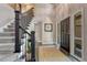 Elegant foyer featuring a staircase with iron railing, tile flooring, and a stylish front door with sidelights at 10289 E Berry Dr, Greenwood Village, CO 80111