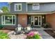 Charming brick home with front porch featuring chairs and potted plants at 10289 E Berry Dr, Greenwood Village, CO 80111