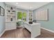 Well-lit home office featuring custom shelving and a large window with a view of lush greenery at 10289 E Berry Dr, Greenwood Village, CO 80111