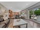 Open living area featuring hardwood floors, a stone accent wall, seamless flow to the kitchen, and outdoor access at 10289 E Berry Dr, Greenwood Village, CO 80111