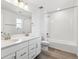 Bright bathroom with double sinks, white cabinetry, and a combined shower-tub at 9266 Telluride Ct, Commerce City, CO 80022