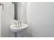 Half bath featuring a pedestal sink and modern round mirror at 9266 Telluride Ct, Commerce City, CO 80022