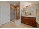 Bathroom featuring a glass-enclosed shower, stone tile floor, and vanity with modern lighting at 4545 S Monaco St # 243, Denver, CO 80237