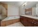 Relax in this spacious bathroom with a soaking tub, a glass shower, and dual vanities at 4545 S Monaco St # 243, Denver, CO 80237