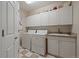 Well-organized laundry room with lots of storage, a utility sink, and checkerboard flooring at 4545 S Monaco St # 243, Denver, CO 80237