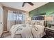 This bedroom features a green accent wall, ceiling fan, and bright, natural light at 9221 High St, Thornton, CO 80229