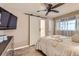 Comfortable bedroom with ceiling fan, TV, and sliding barn door to ensuite bathroom at 9221 High St, Thornton, CO 80229