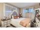 Charming bedroom with a tufted headboard, decorative pillows, and plenty of natural light at 9221 High St, Thornton, CO 80229