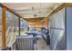 Covered outdoor patio with stainless steel refrigerator and lounge seating at 9221 High St, Thornton, CO 80229