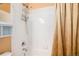 Close-up of bathroom shower with white tile and built in storage, with a neutral shower curtain at 11460 W Tanforan Cir, Littleton, CO 80127