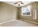 Bedroom featuring neutral carpeting, an empty room, a ceiling fan, a large window, and a mirror on the wall at 11460 W Tanforan Cir, Littleton, CO 80127