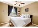 This cozy bedroom features a ceiling fan, a window with dark curtains, and is furnished with a wood frame bed at 11460 W Tanforan Cir, Littleton, CO 80127