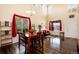 Open-concept dining room with dark hardwood floors, chandelier, and plenty of natural light at 11460 W Tanforan Cir, Littleton, CO 80127