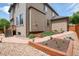 Exterior view of the home highlighting the two-story design, lush landscaping, and outdoor walkway at 11460 W Tanforan Cir, Littleton, CO 80127