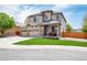 Two-story home featuring a three-car garage, manicured lawn, and inviting front porch at 11460 W Tanforan Cir, Littleton, CO 80127