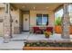 Inviting front porch with stone accents, seating area, and beautiful flower bed at 11460 W Tanforan Cir, Littleton, CO 80127