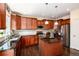 A kitchen featuring wood cabinets, granite countertops, stainless steel appliances, and an island with pendant lighting at 11460 W Tanforan Cir, Littleton, CO 80127