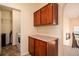 Practical laundry room with wood cabinets, countertop space, and modern appliances at 11460 W Tanforan Cir, Littleton, CO 80127