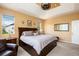 A well-lit primary bedroom featuring a large bed, ambient lighting, and neighborhood views at 11460 W Tanforan Cir, Littleton, CO 80127