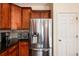 A stainless steel refrigerator complements the warm wood cabinets and granite countertops in this kitchen at 11460 W Tanforan Cir, Littleton, CO 80127